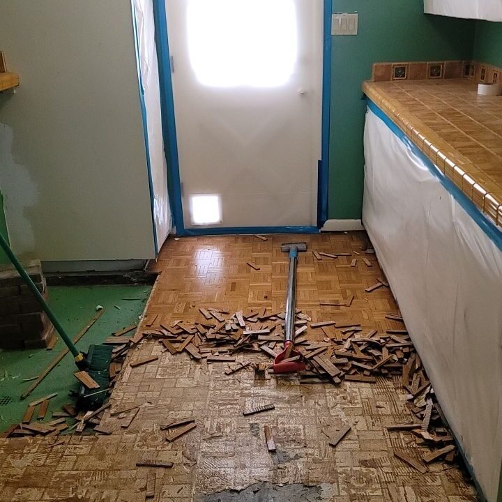 an asbestos tile floor being removed from a kitchen